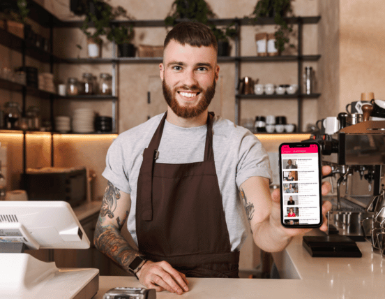 Barista displaying mobile hospitality learning platform in café environment